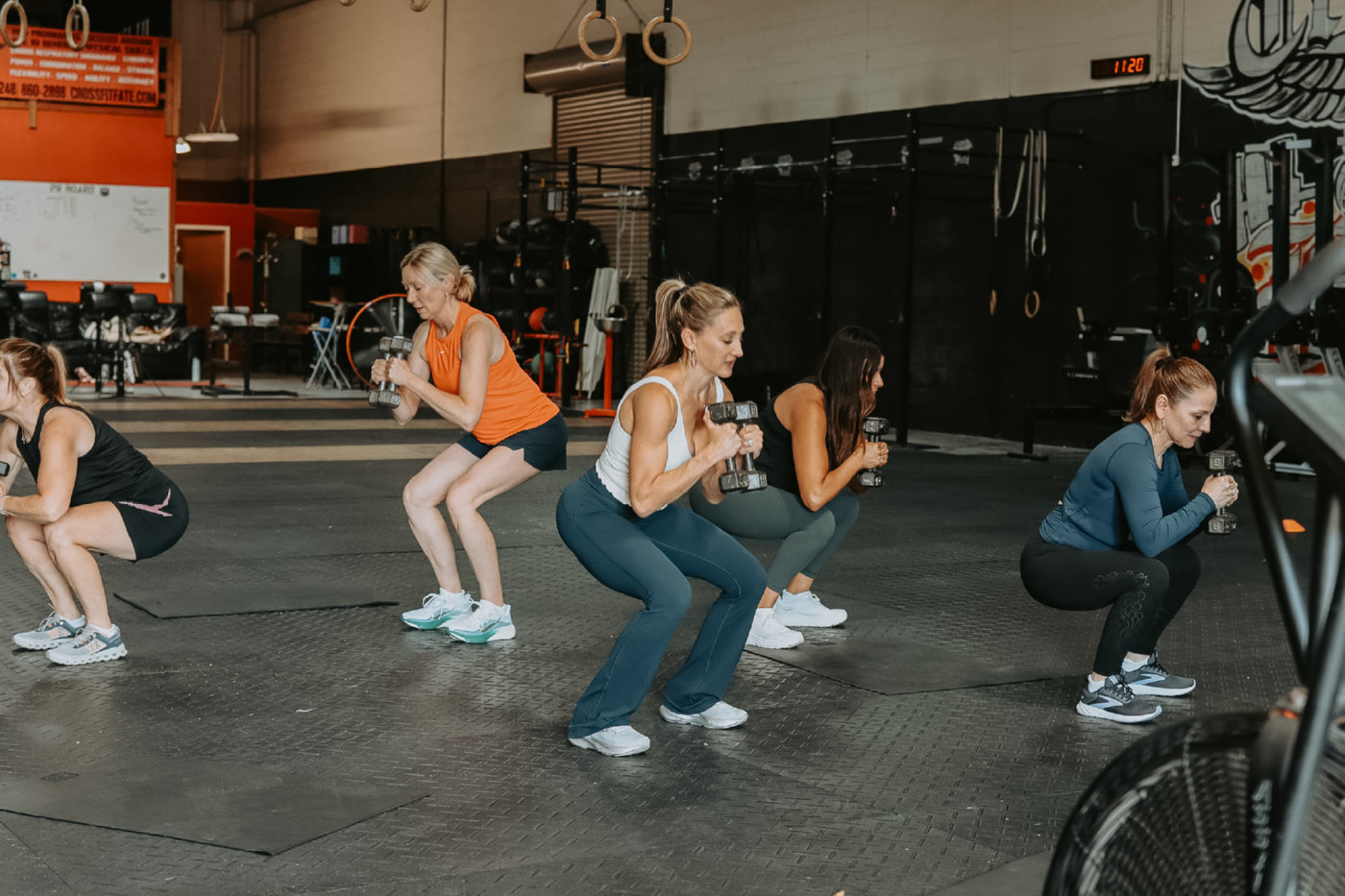 Group class mid-squat with dumbbells